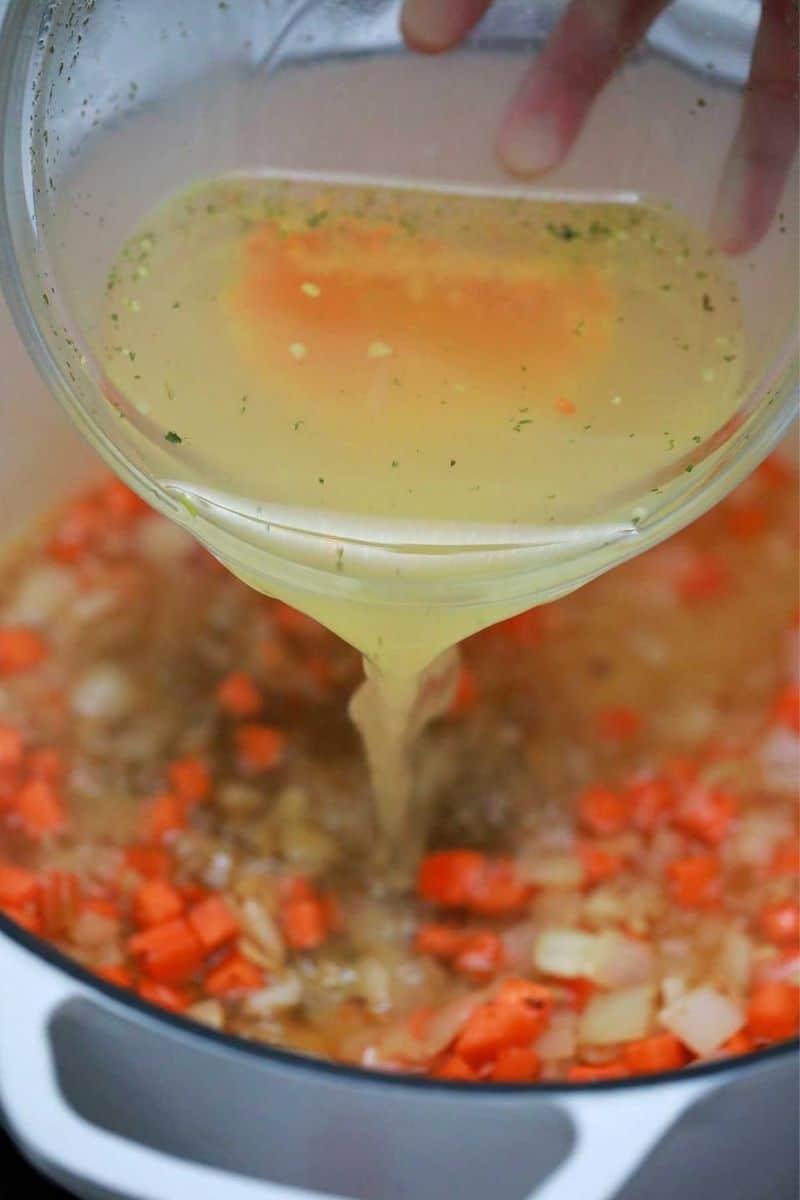 Adding broth to soup pot