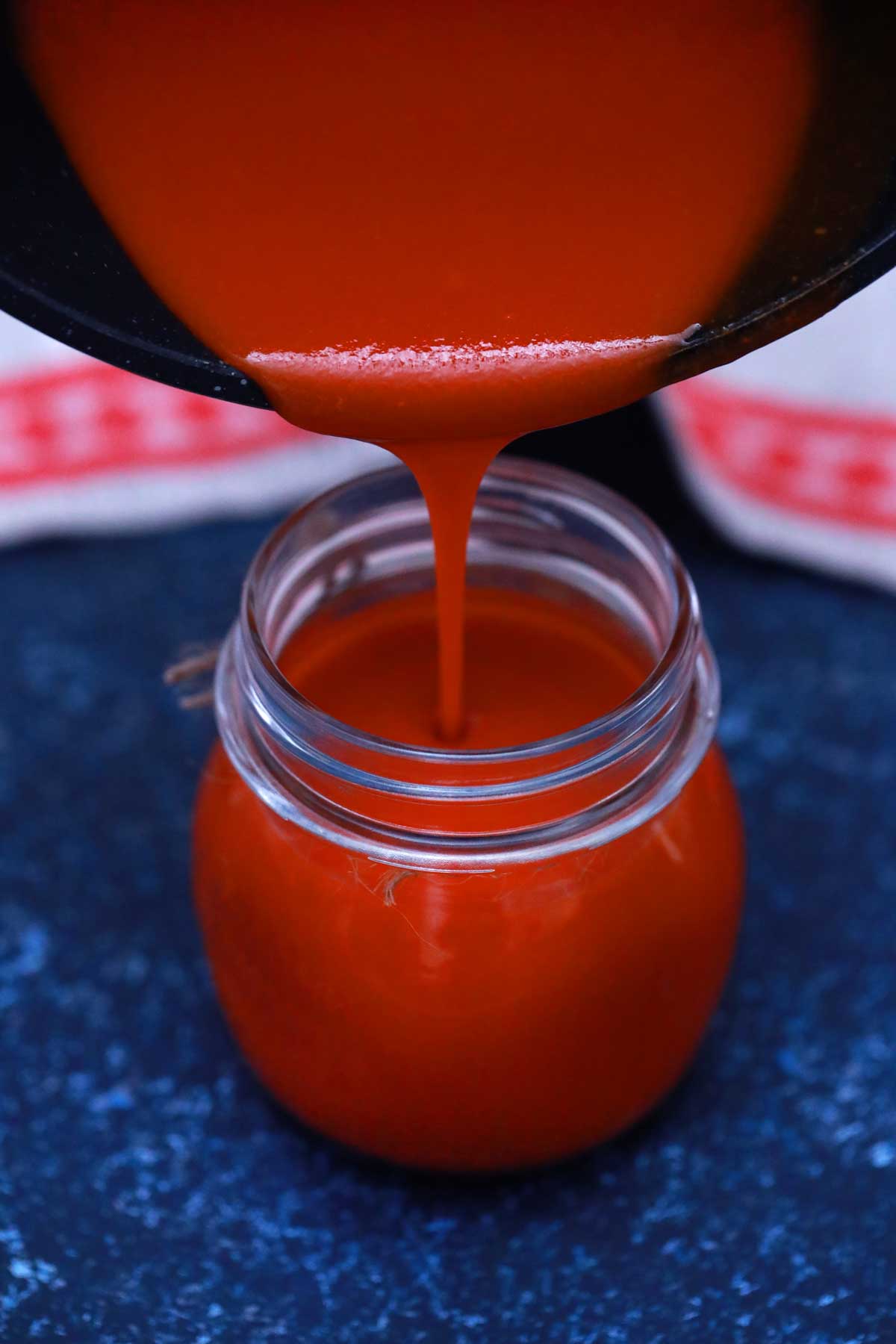 Pouring sauce from pan into jar