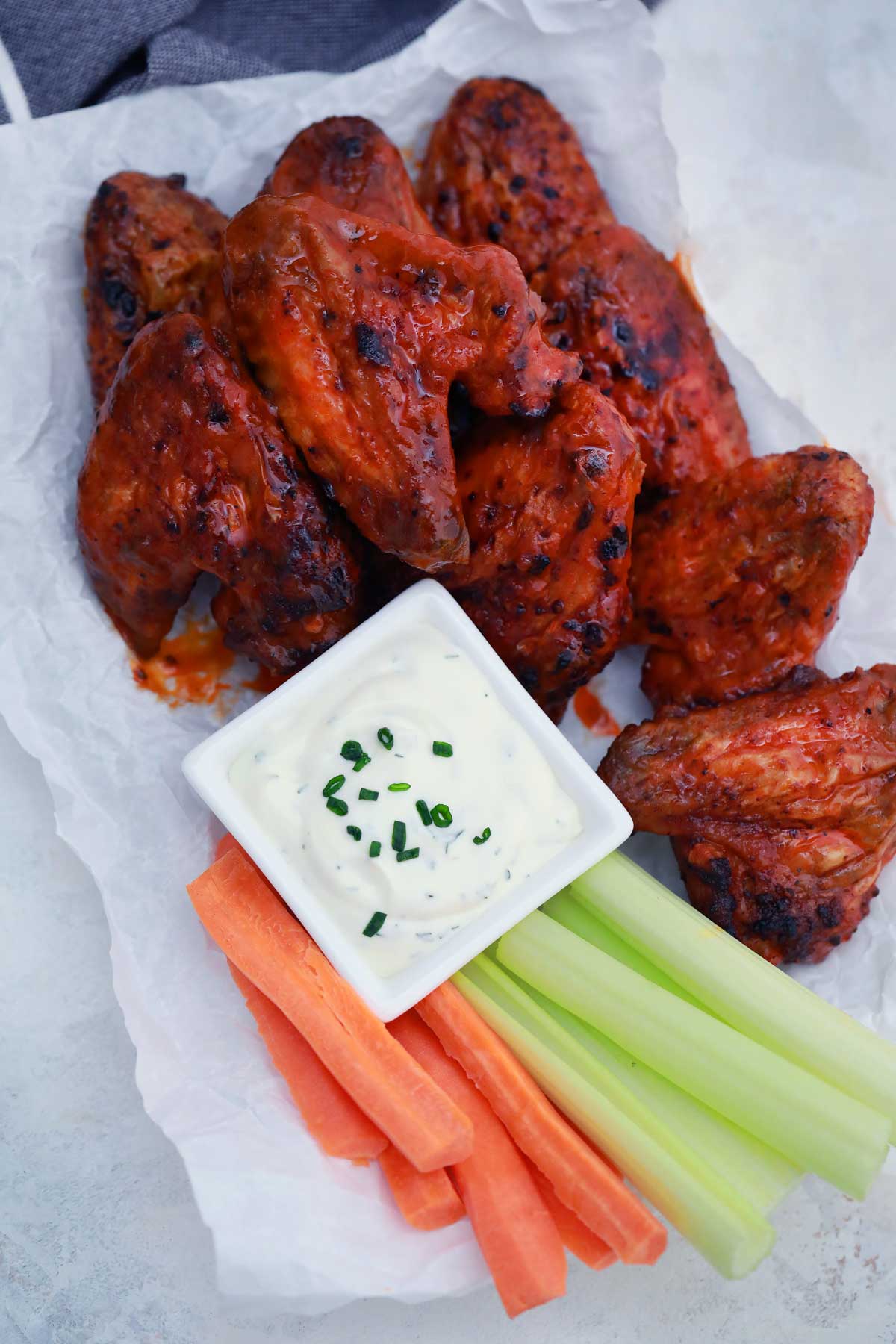 Buffalo chicken wings on white plate with dip