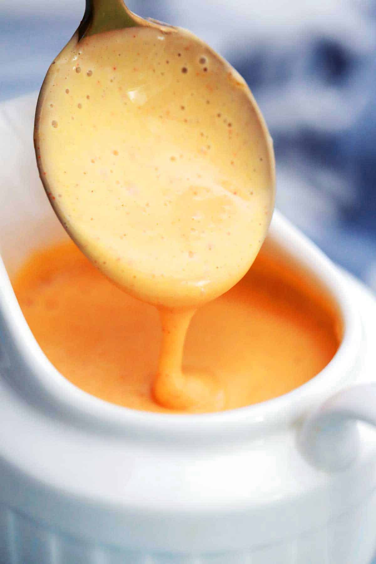 Spoon dripping hollandaise sauce