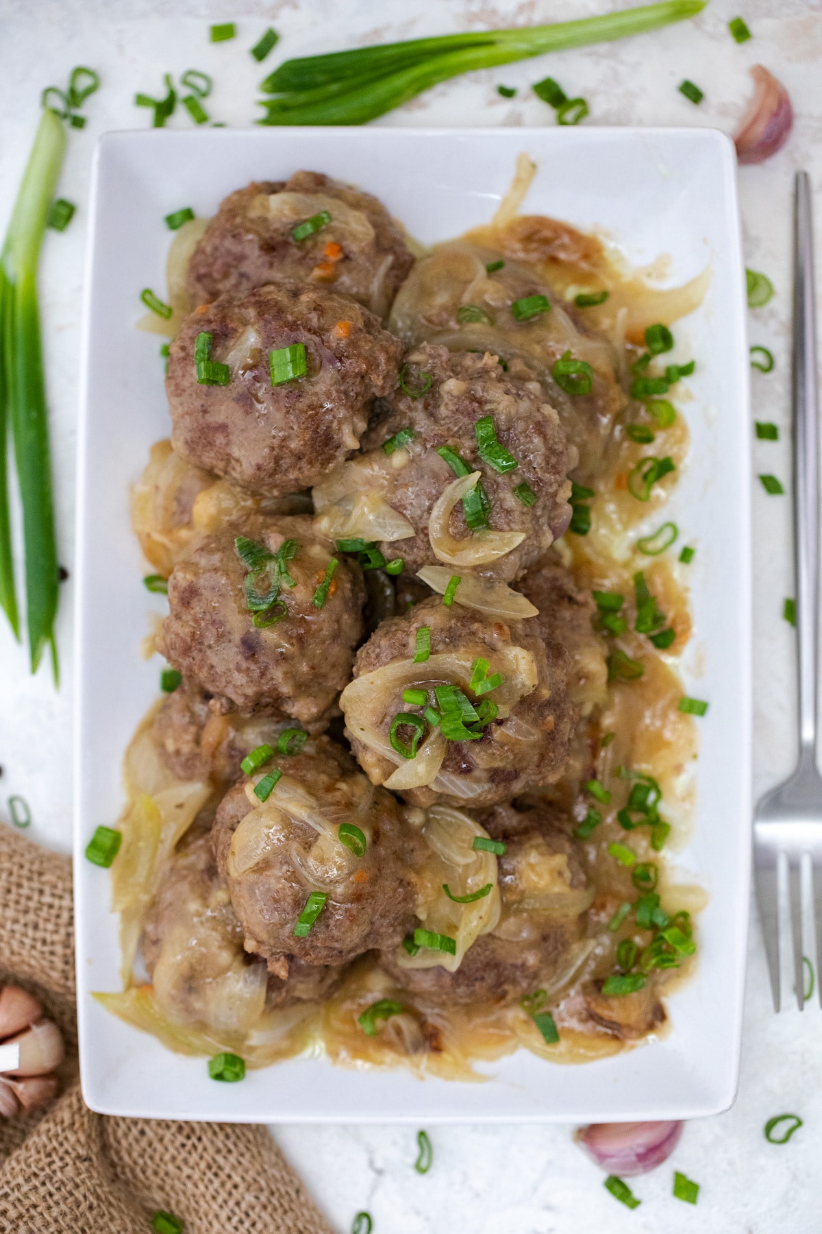 Ground beef steaks with gravy on white platter