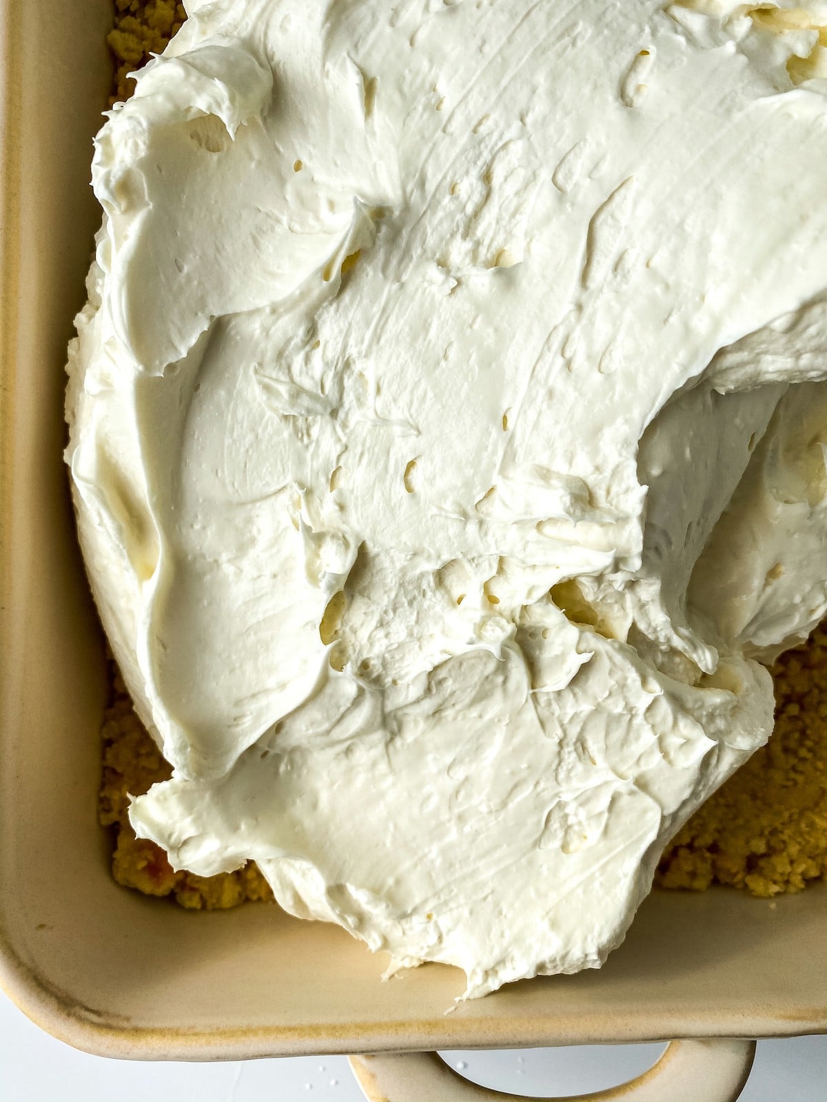 Spreading cream cheese into baking dish