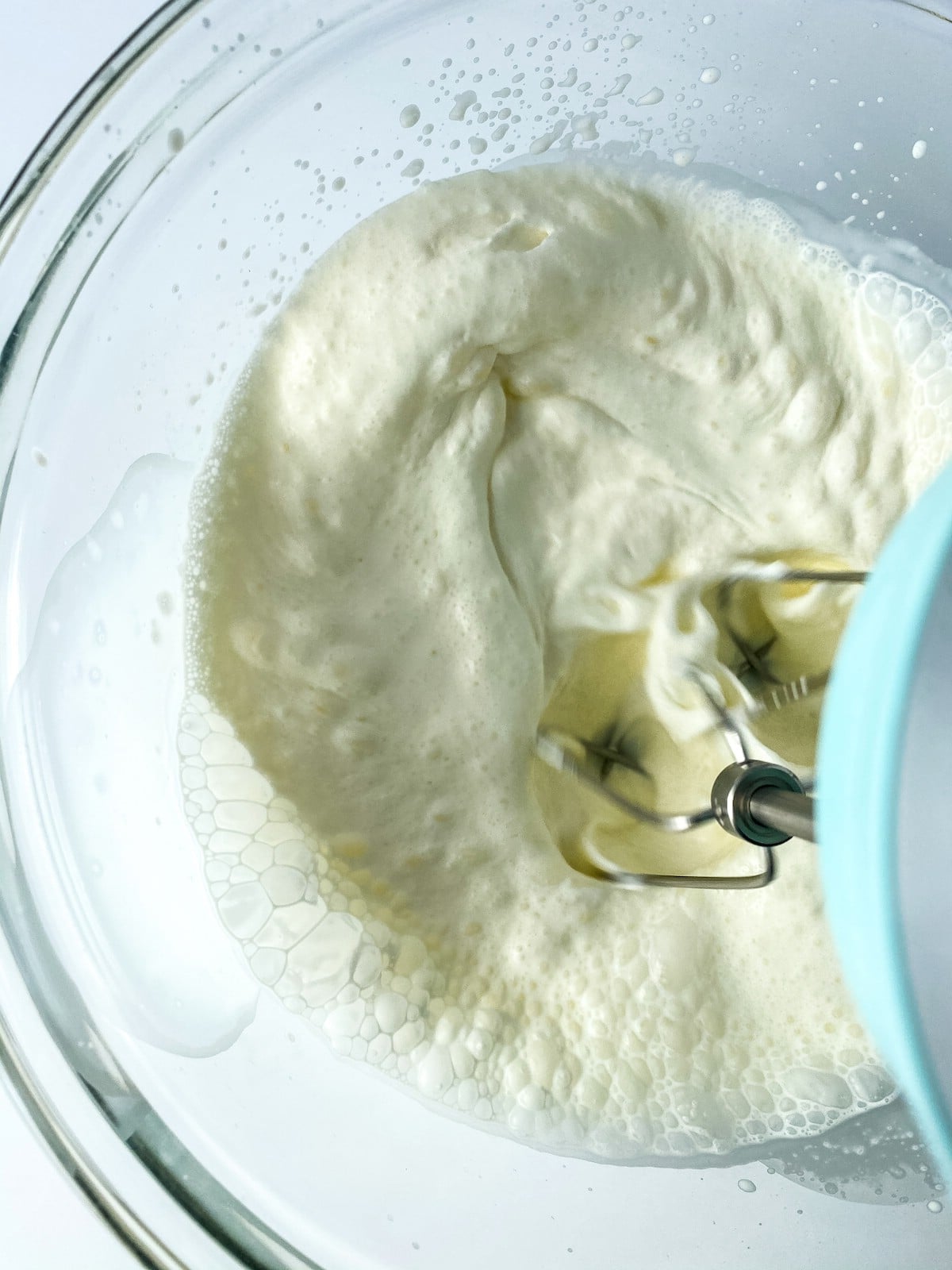Beating cream cheese in glass bowl