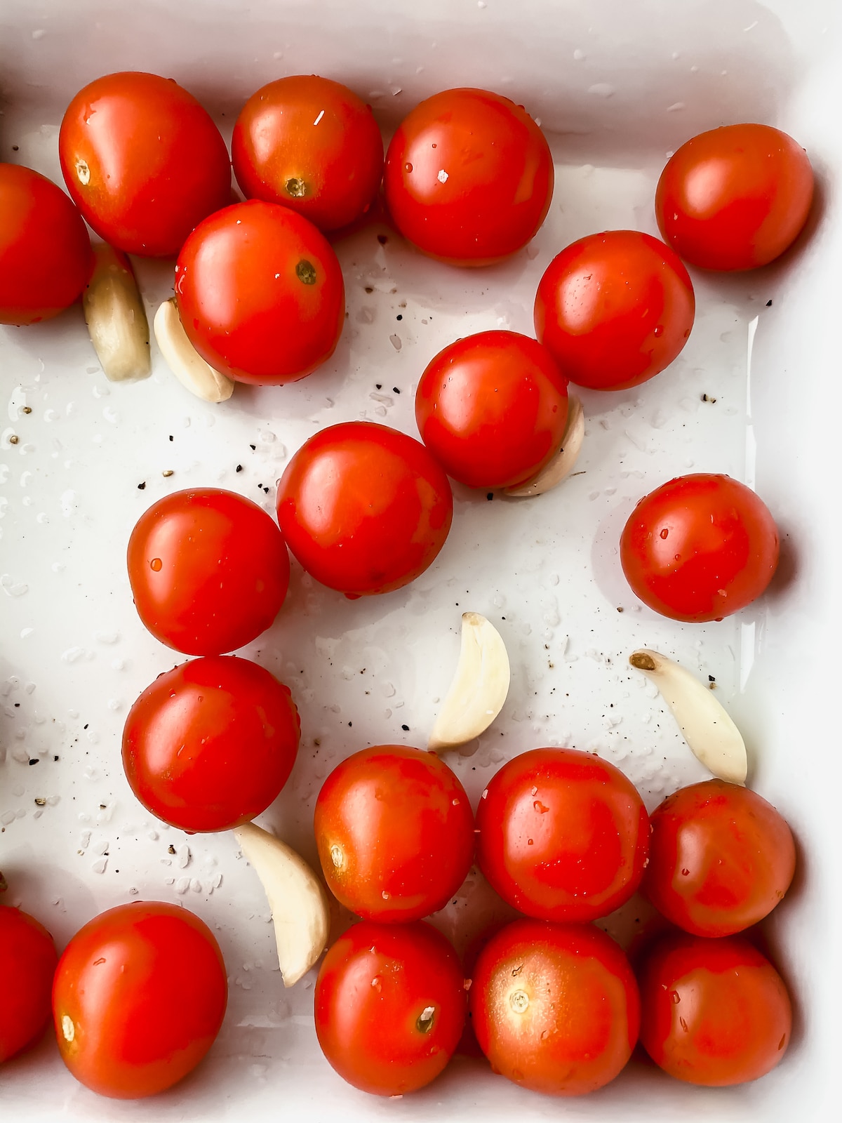 Tomatoes in baking dish with garlic