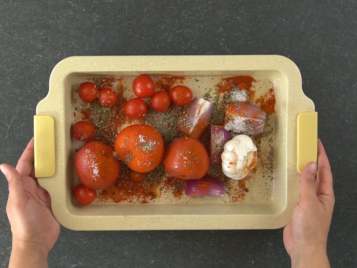 cream baking dish with tomatoes spices onion and garlic