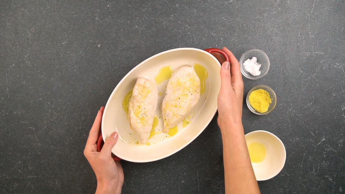 raw chicken in oval baking dish