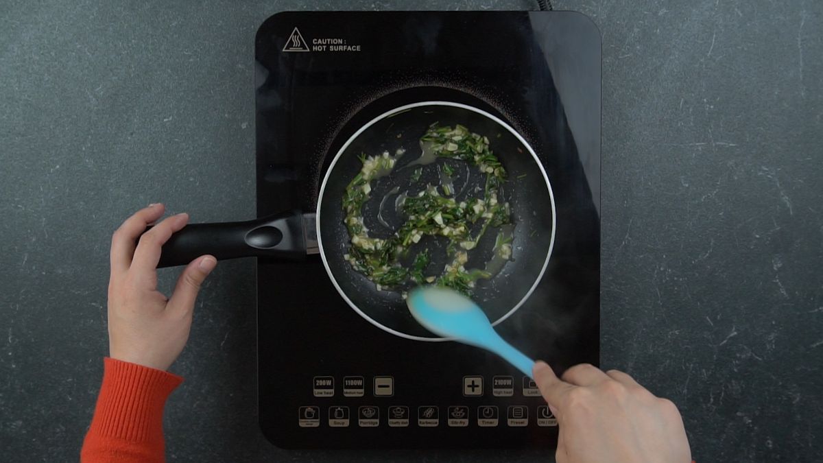 teal spoon in skillet with parsley and garlic