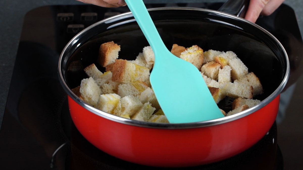 teal spatula stirring bread in skillet