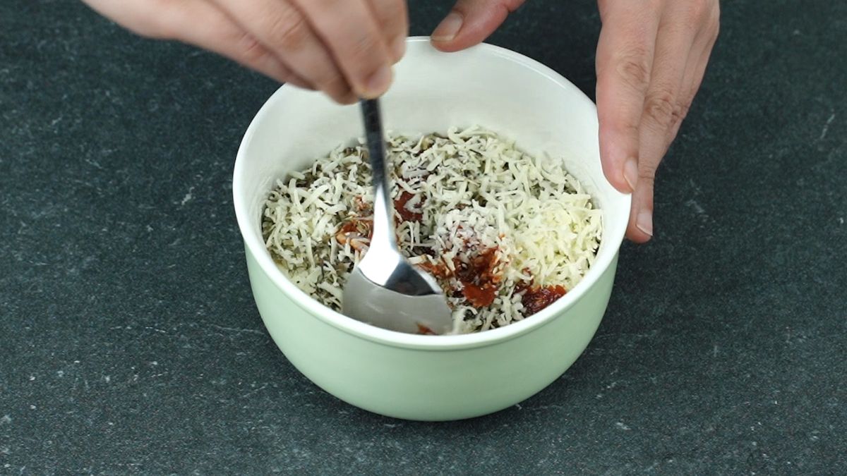spoon stirring sauce in white bowl