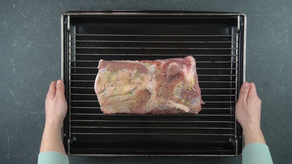 raw pork loin on top of rack on roasting pan