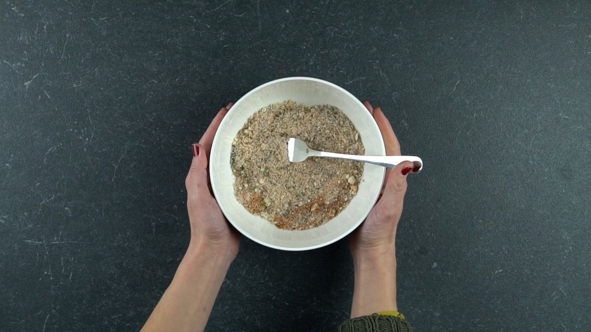 white bowl of herbs with fork in center