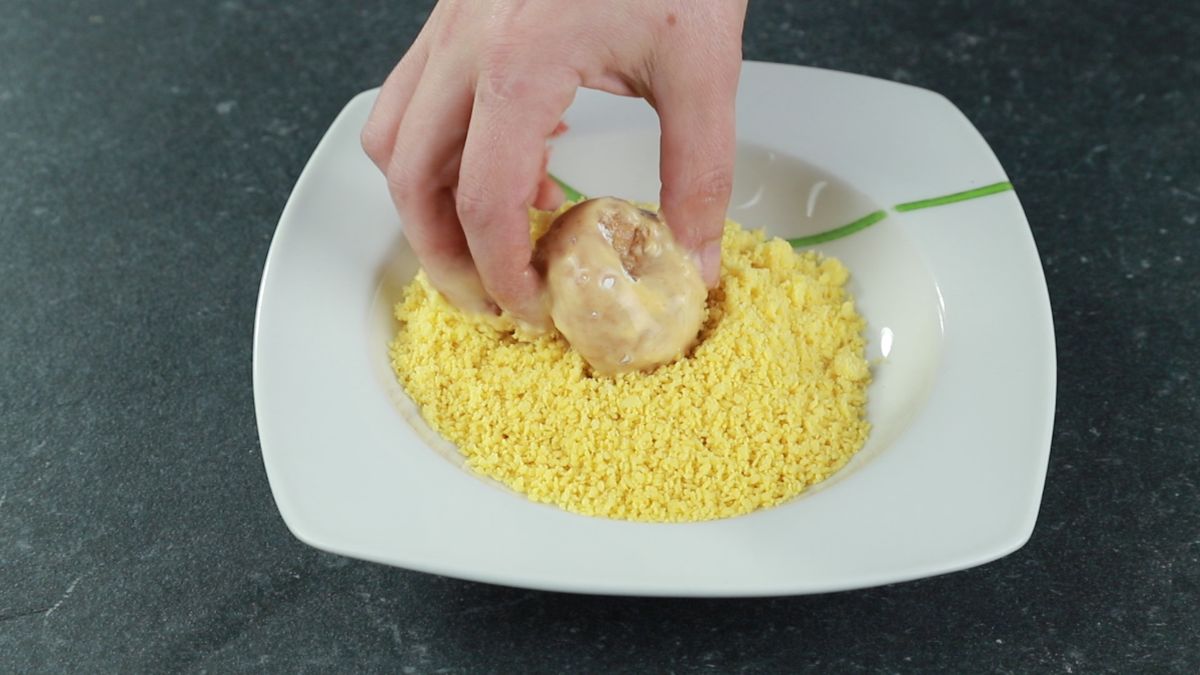 hand rolling chicken bomb in pringles crumbs