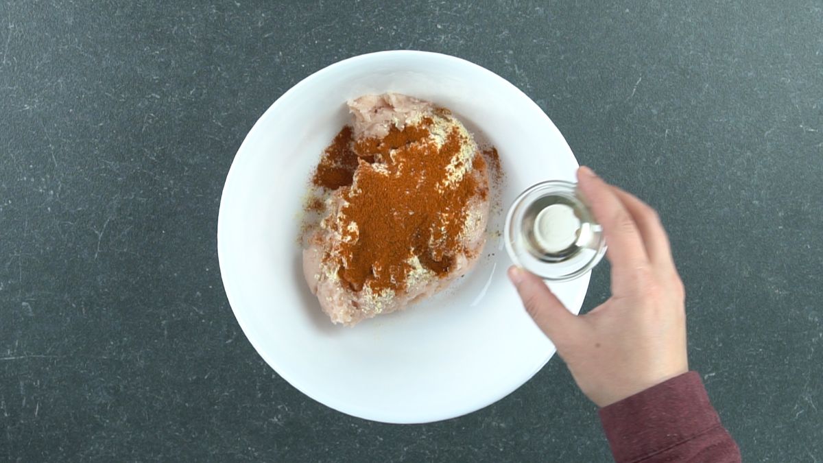 ground chicken with spices in large white bowl