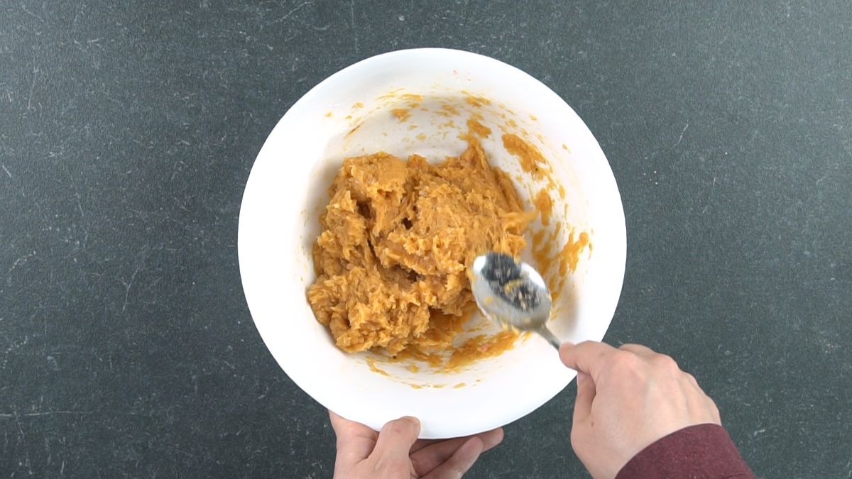 spoon stirring chicken with spices