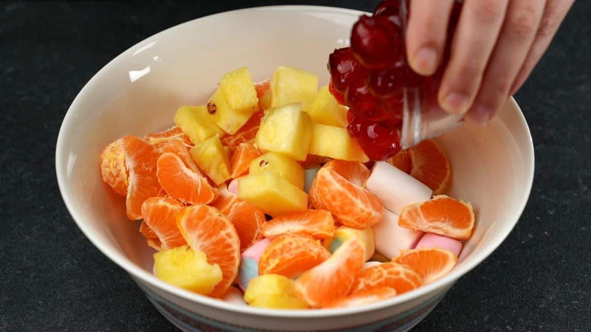 white bowl of pineapple orange and cherries