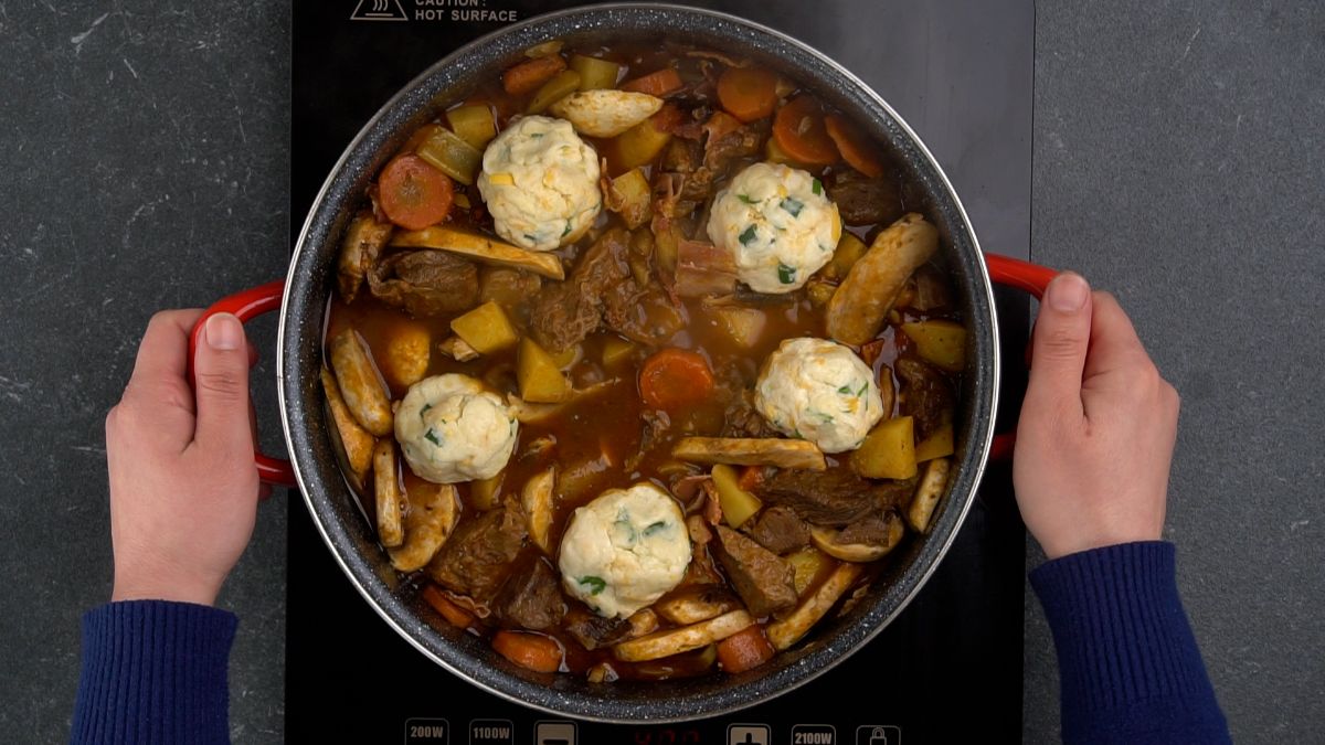 cheddar biscuits on top of stockpot of stew