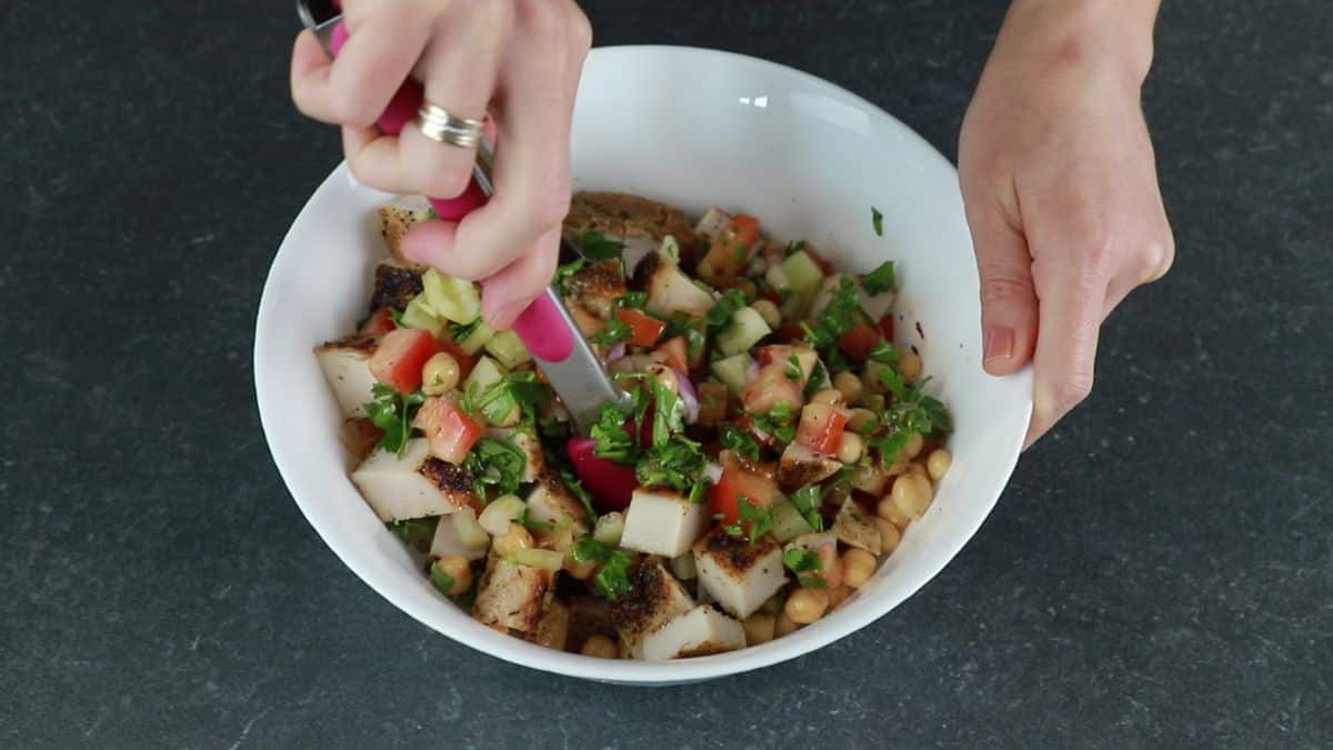 tongs tossing chickpea chicken salad