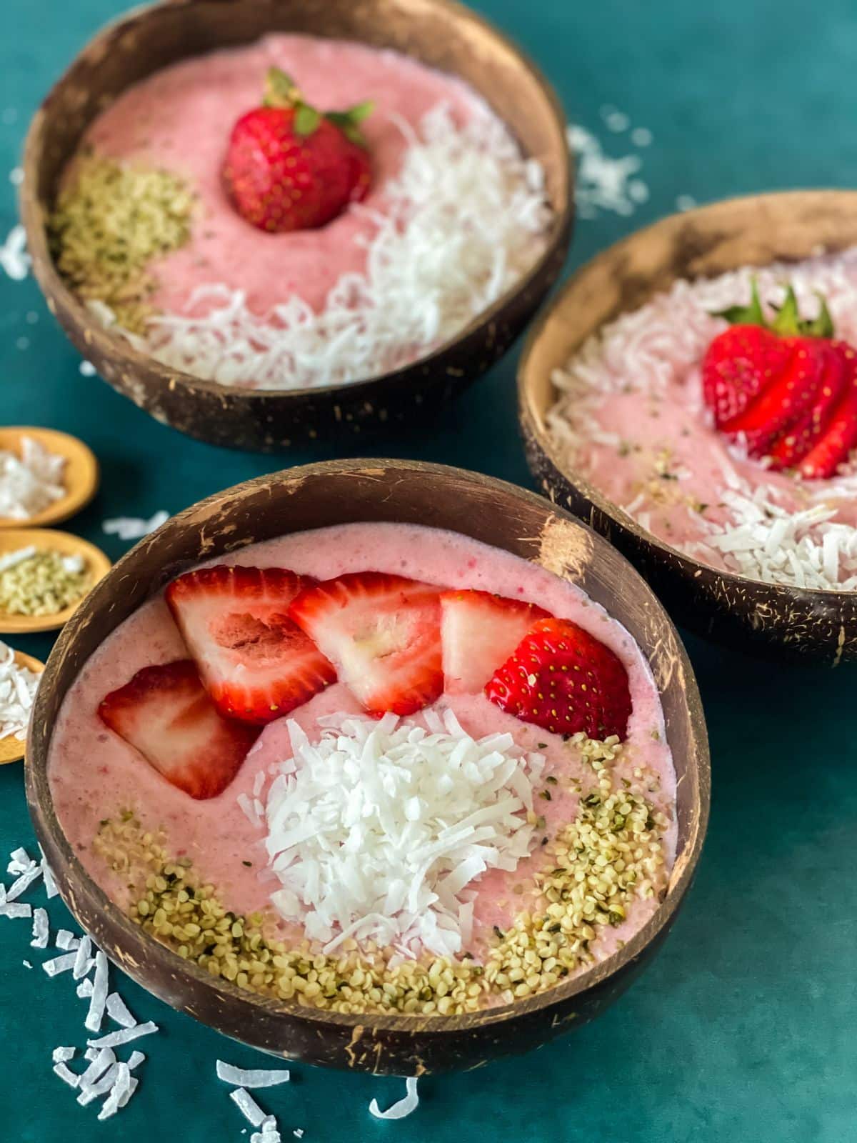 three brown bowls of strawberry banana smoothie
