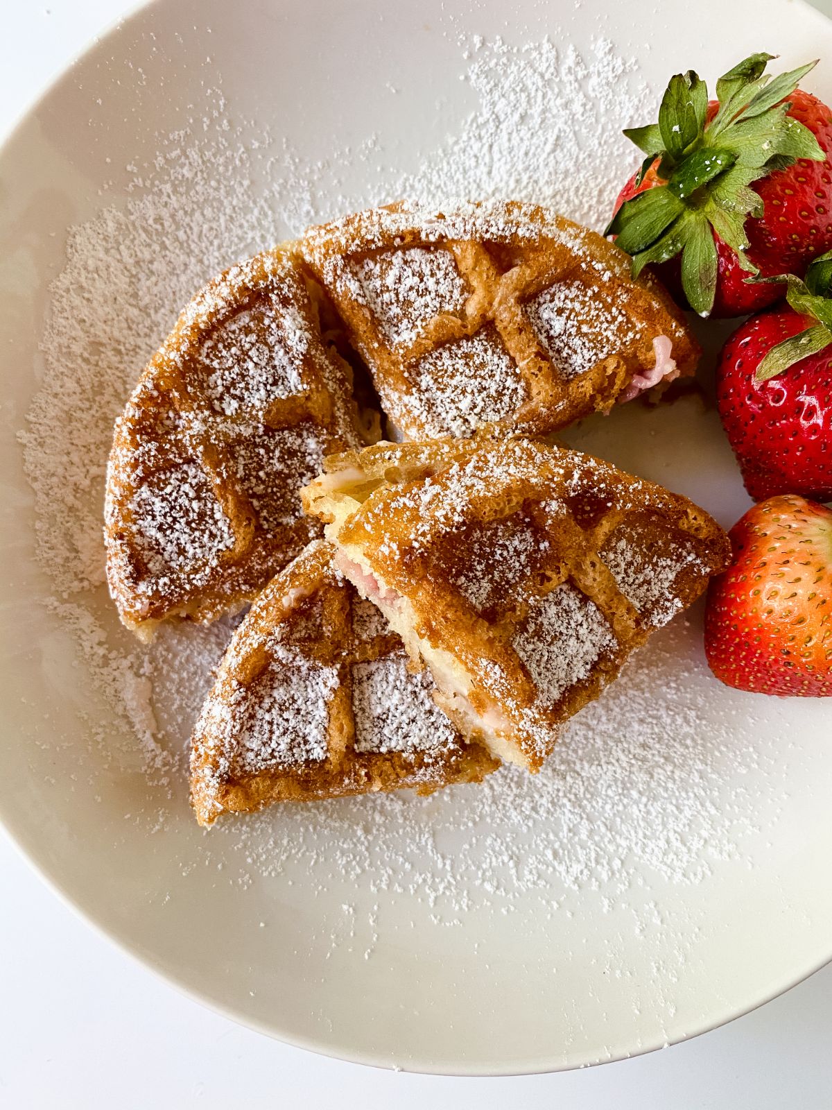 cream plate holding strawberry cream cheese stuffed waffles