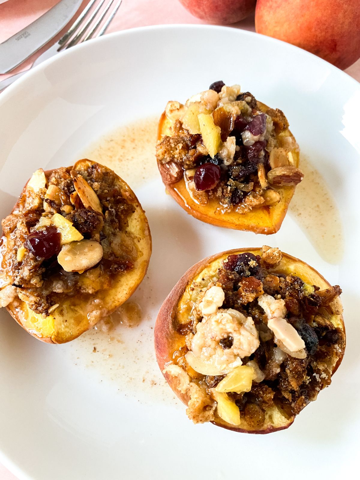 three peach halves topped with crumble on white plate